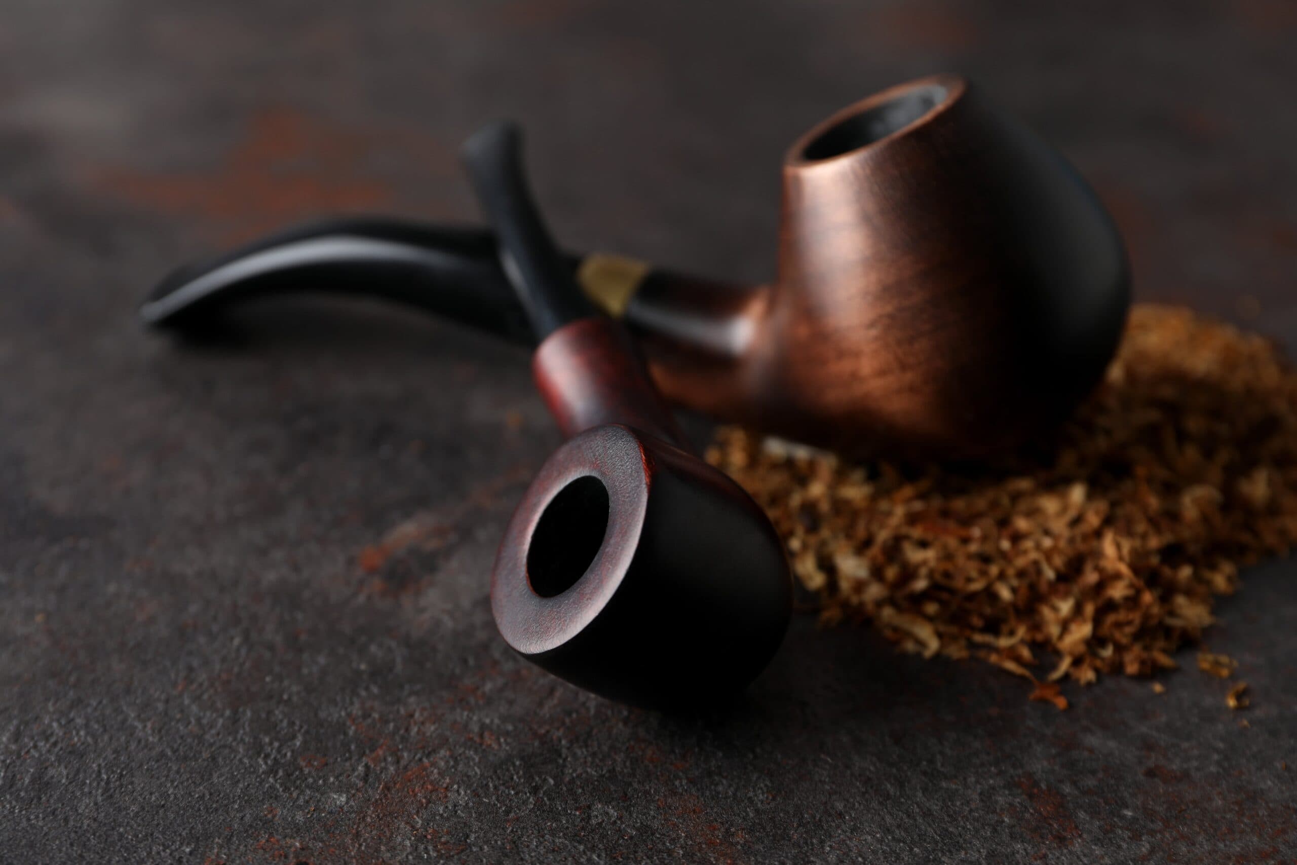 smoking-pipes-with-tobacco-on-dark-textured-backgr-2022-08-03-10-56-58-utc-min-scaled